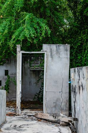 A partially destroyed wall, with crumbling concrete and peeling paintの写真素材