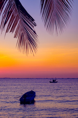 Infrered photography, a serene sunset over a body of water. In the foreground, boat floating gently on the waterの写真素材