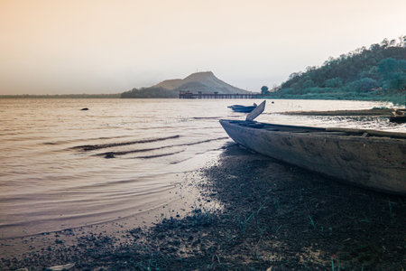 Infrared photography, a wooden boat rests on the sandy shore of a lake, its bow pointed towards the water.の写真素材
