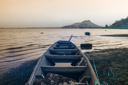 Infrared photography, a weathered wooden boat sits on the shore of a calm lakeの写真素材