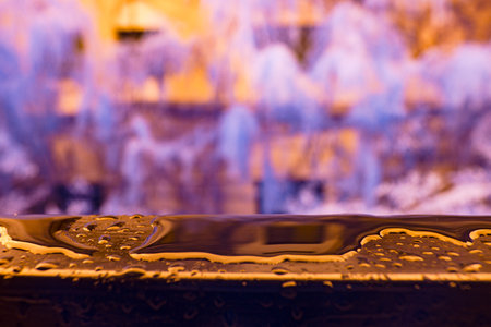 Infrared photography, a close-up view of a surface with water droplets on it, set against a blurred, colorful backgroundの写真素材