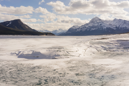Landscape of broken ice on Abraham Lake with mountains in the background, Alberta, Canada.の写真素材
