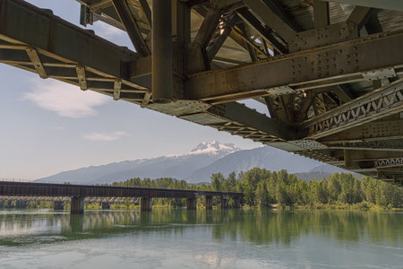 Landscape looking out from under the Revelstoke Suspension Bridge with a view of the Revelstoke Railroad Bridge, British Columbia, Canadaの写真素材