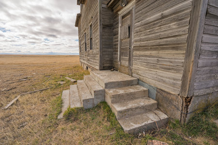 Looking at the door and steps of an abandoned farm house, Saskatchewan, Canadaの写真素材