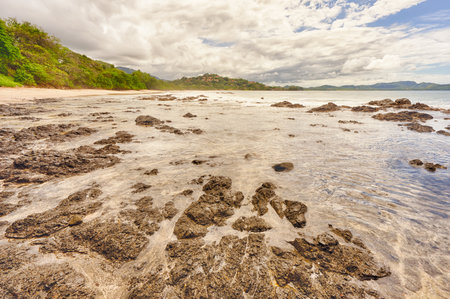 Textured Ocean Landscape at Flamingo Beach, Costa Rica.  Rocky foreground and a cloudy  sky.