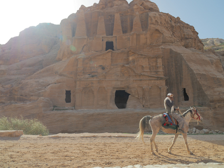 Petra, Jordan - March 7th, 2018: Local guide rides horse around Patre city.のeditorial素材