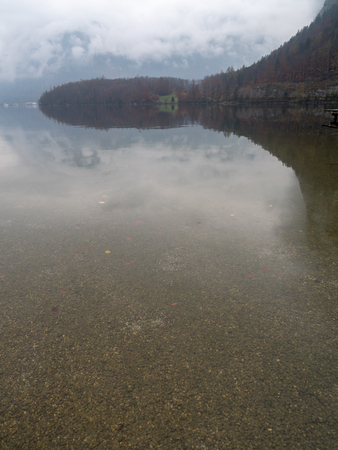 Hallstatt lake in the morning with mist from Obertraun shoreの写真素材