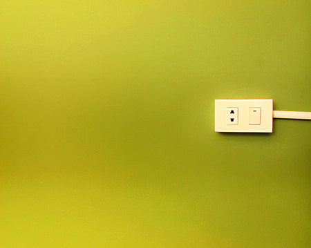 Electrical switch and plug on the green wall backgroundの写真素材