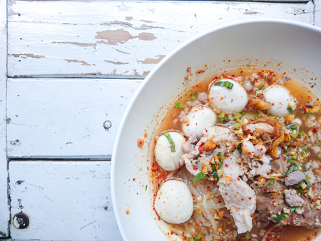 Closeup Spicy TOM YAM Pork Noodles Soup with Pork Balls, chilly pasted and lime juice / Noodles in Thai spicy tom yum soup with porkの写真素材
