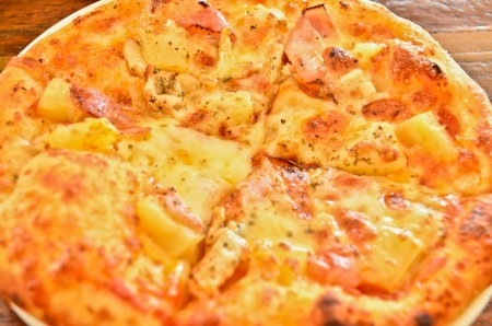 delicious hawaiian rustic style pizza made with fresh pineapples,ham and mozzarella cheeseの写真素材
