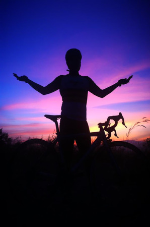 Biker at the sunset on the meadowの写真素材