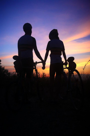 Biker at the sunset on the meadowの写真素材