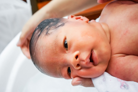 First bathing of a newborn baby boy in a  bathtub.の写真素材