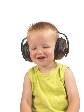 toddler sitting with headphones on his head on a white backgroundの写真素材