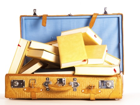 a travel suitcase full of books on a white backgroundの写真素材