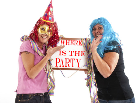 two cheerful ladies in party mood with a billboardの写真素材