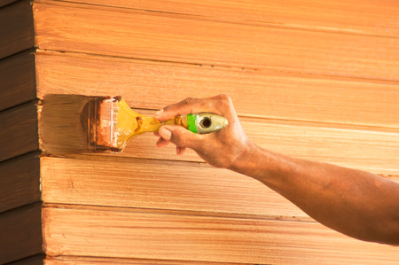 Brush in hand and painting  wooden poleの写真素材