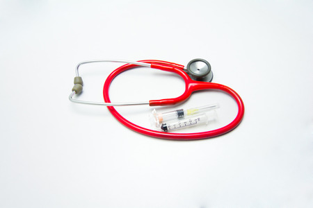 Red stethoscope and syringes in gray backgroundの写真素材