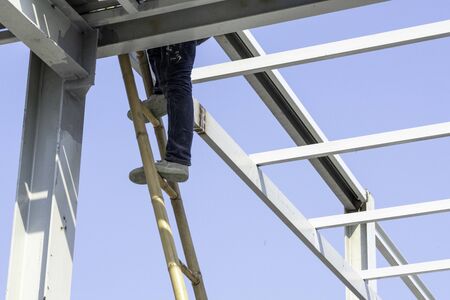 A man climbing on a wooden ladder.