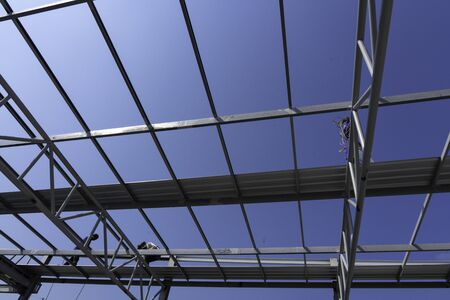 Three men are installing the roofing sheet on Light steel Truss and Frame construction.の写真素材