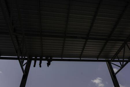 Two men are relaxing the roofing sheet on Light steel Truss and Frame construction.の写真素材