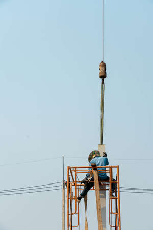 Mobile Crane helped worker install stell H-beam pole.のeditorial素材