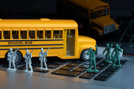 Soldier toy set protecting school bus on laptop, concept safety. Terrorist Hijacking the school bus.の写真素材