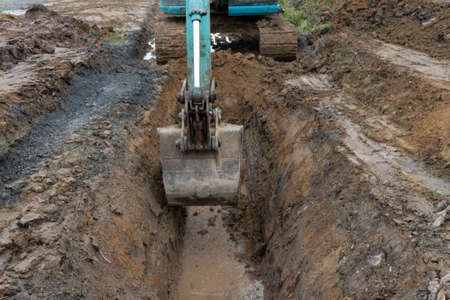 Bucket of Backhoe or Crawler excavator is digging earth.の写真素材