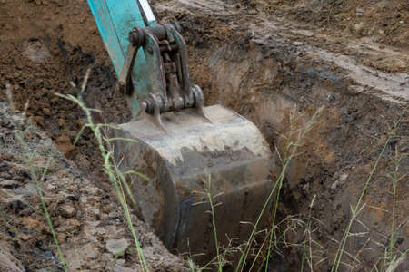Bucket of Backhoe or Crawler excavator is digging earth.の写真素材