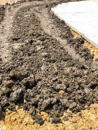 Tractor wheel tracks after dozer.beside concrete road.