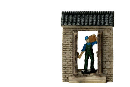 A model delivery in blue shirt and green apron uniform carrying a box and standing at the door. An online or offline Delivery service concept isolated on white backgrounds.の写真素材