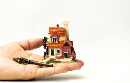 A model house and a key on human hand and stack of coins and Isolate on white background. Concept ideas for Financial housing plan. Concept ideas , Save up for a new house.の写真素材