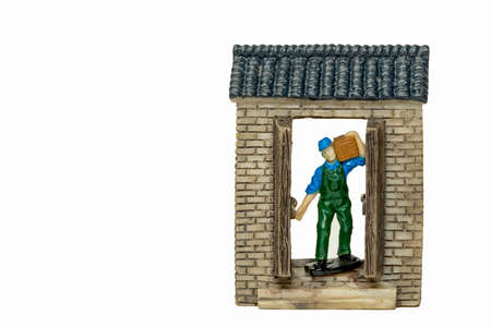 A model delivery in blue shirt and green apron uniform carrying a box and standing at the door. An online or offline Delivery service concept isolated on white backgrounds.の写真素材
