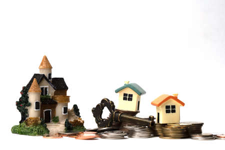 Coins and Tiny house with key. Escrow service Concept ideas. sale and purchase of real estate. Isolated on white background. copy space.の写真素材