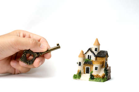 A model house and a key on human hand and stack of coins and Isolate on white background. Concept ideas for Financial housing plan. Concept ideas , Save up for a new house.の写真素材