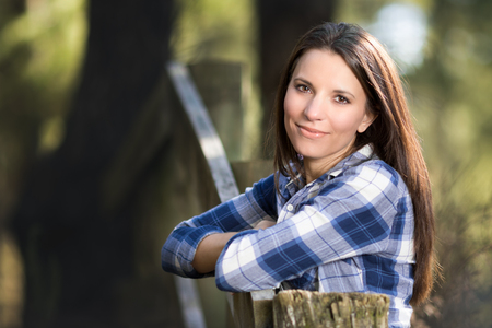Beautiful woman leaning on fenceの写真素材