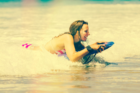 Happy girl boogie boarding at beach