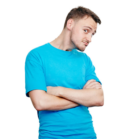 Weird young man wearing blue t-shirt keeping arms crossed while standing isolated on white. Creepy comic expressionの写真素材