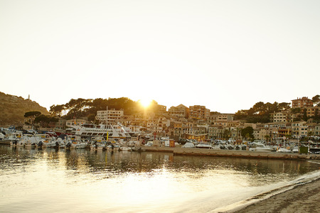 Sunset in Port Soller with docked yachts and boats. Houses on hillside of Puerto de Soller.の写真素材