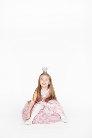 Vertical full body portrait of cute little girl child with blond hair and pink dress isolated on white background with copy space above headの写真素材