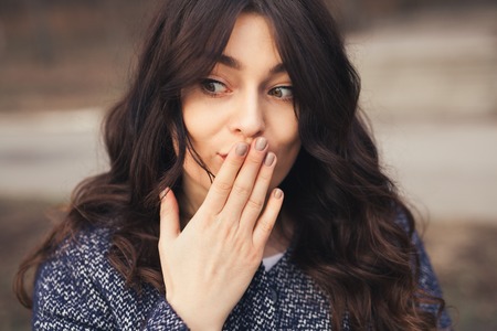 beautiful brunette woman. Oops concept Close up plus size girl holding hand on mouth. Female did a mistakeの写真素材