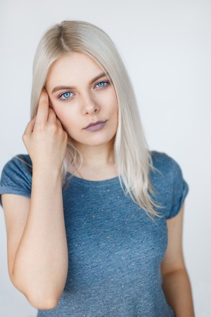 Vertical portrait of young beautiful woman with white hair posing over grey background. Clean t-shirt mockupの写真素材