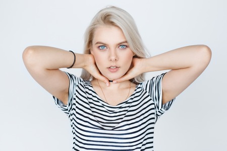 Close-up awesome caucasian attractive female model with blond hair posing in studio wearing striped shirt and, isolated on grey backgroundの写真素材