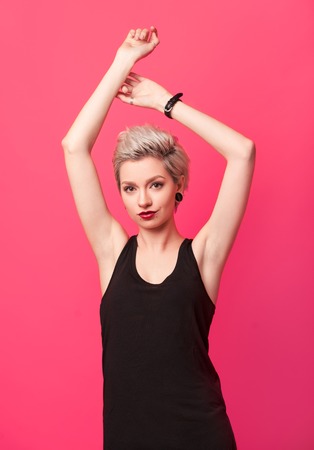 girl with bright make-up posing against pink backgroundの写真素材