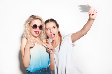 Friends gesturing and taking selfieの写真素材