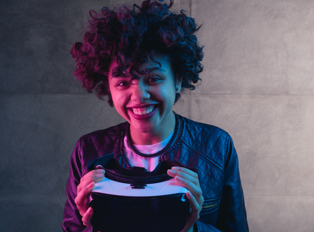 Smiling woman holding VR deviceの写真素材