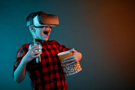 Cheerful boy with popcorn in VR headsetの写真素材