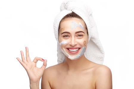 Woman gesturing ok with cosmetics on faceの写真素材
