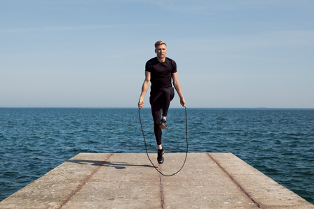 Man jumping rope on pierの写真素材