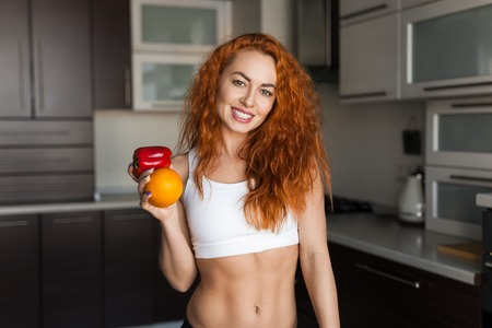 Smiling woman with orange and pepperの写真素材